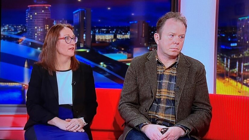 Man and woman sat next to each other on sofa on news show